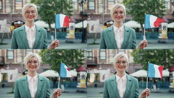 慢动作快乐法国女孩手持国旗微笑站在户外