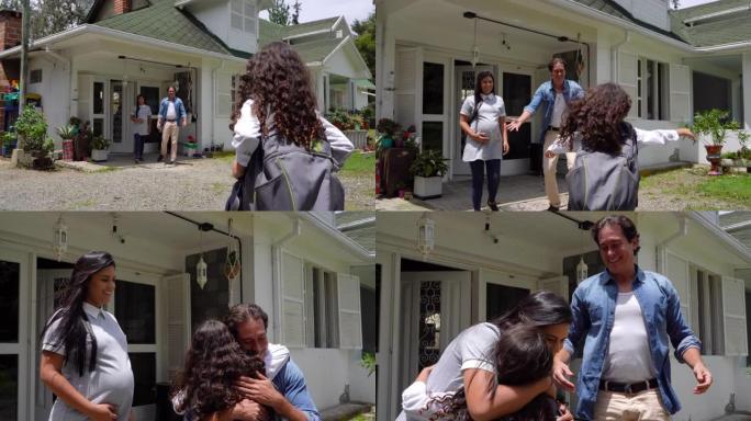 可爱的女儿放学后回到家中，父母在外面等着拥抱她非常高兴