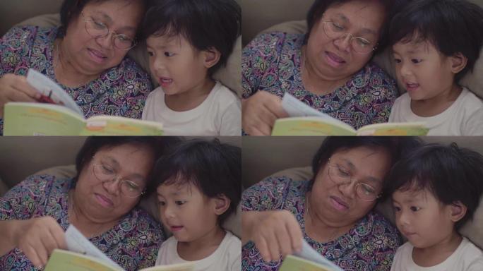 亚洲小男孩和祖父母在床上看书