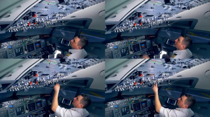 专业飞行员正在调节飞机驾驶舱甲板上的各种开关。