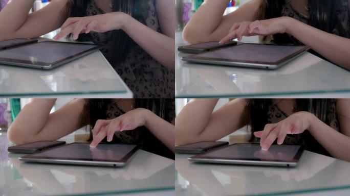 亚洲妇女在家在平板电脑上手工阅读电子书