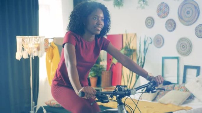 在家运动，在家健身的概念。开朗的非洲女士正在使用运动周期进行禁闭训练