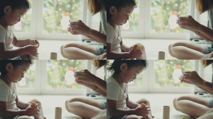 年轻的亚洲母子用纸艺制作玩具