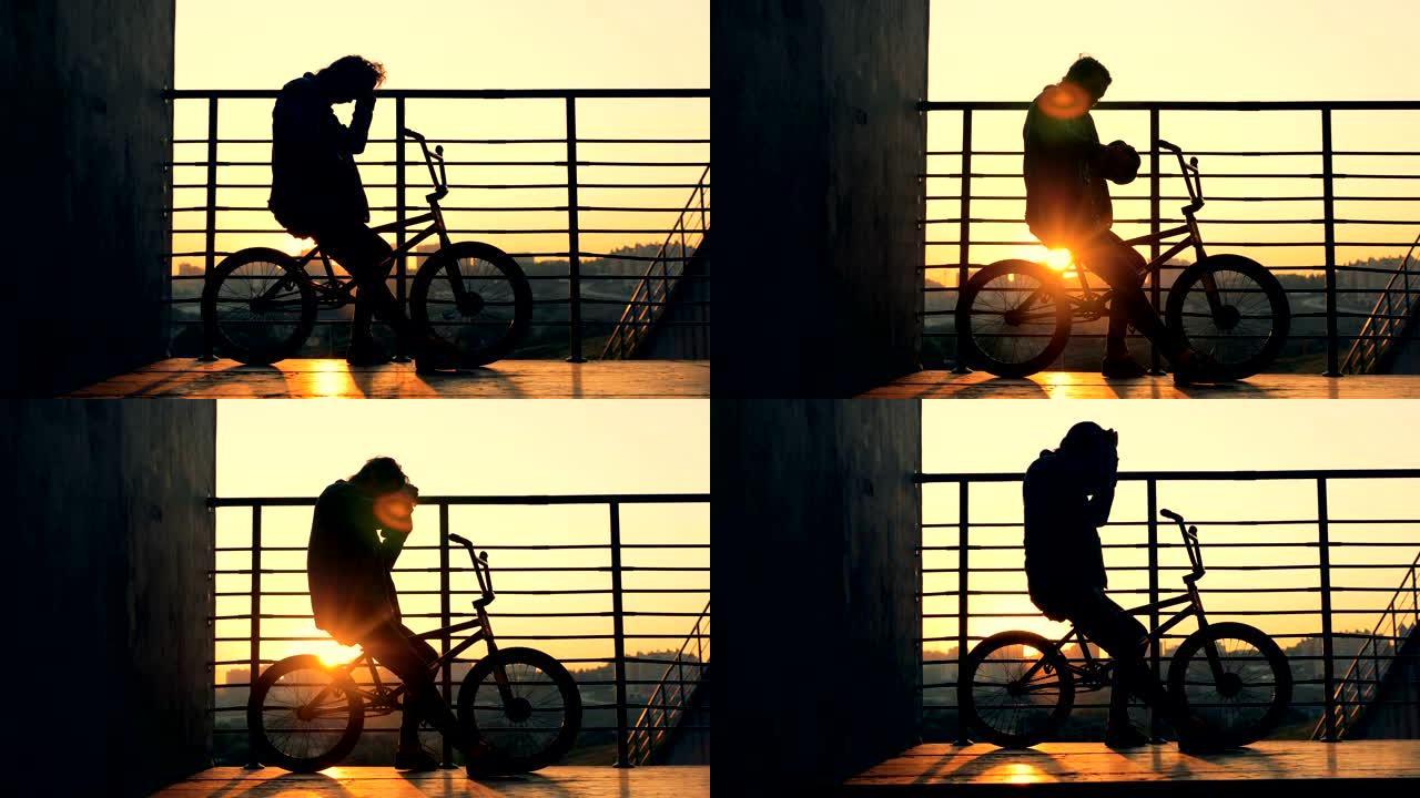 一个人坐在日落背景上的自行车上，近距离拍摄。