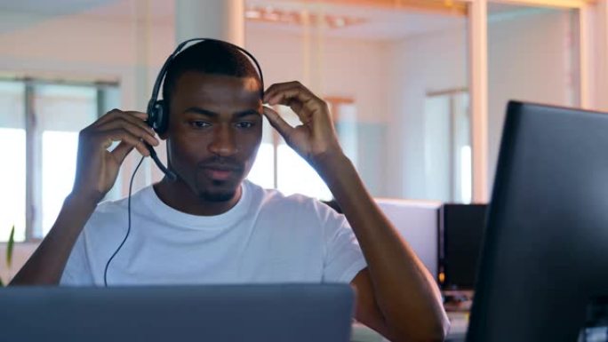 现代办公室4k桌上电脑工作的年轻黑人男性高管的前视图