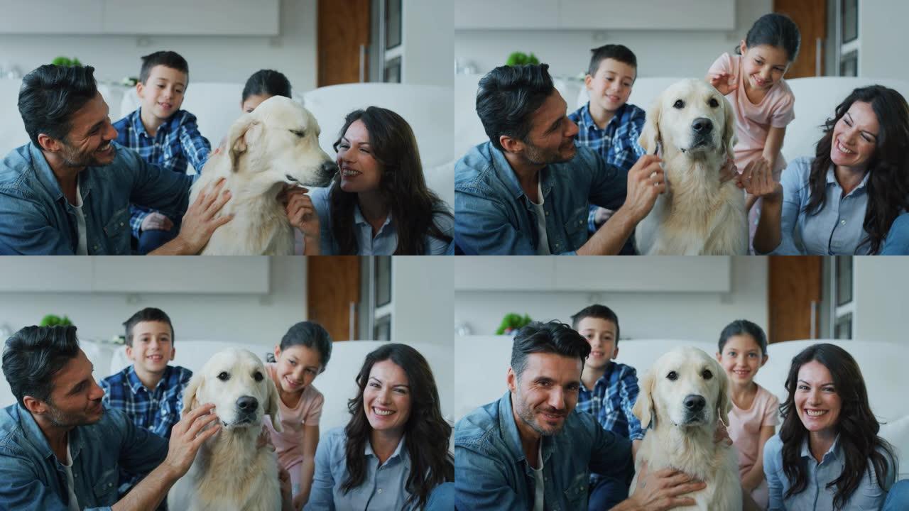 幸福家庭的肖像在慢动作中拥抱他们的狗在客厅里玩得开心。