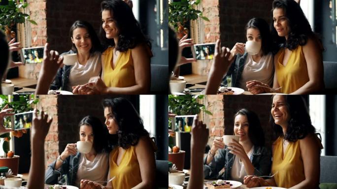 漂亮的女士在咖啡馆喝咖啡，用智能手机笑着拍照