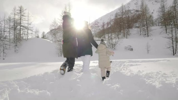 在冬天的日子里，山里的一家人在雪地和大自然中漫步。
