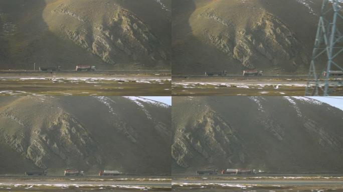 慢动作: 两辆货运卡车沿着西藏的一条河沿着道路行驶。
