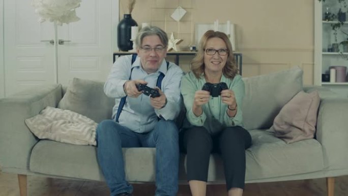年老的男人和女人正在家里玩电子游戏