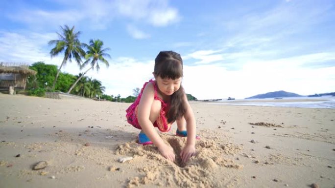 快乐的小女孩早上在美丽的海滩上玩沙子