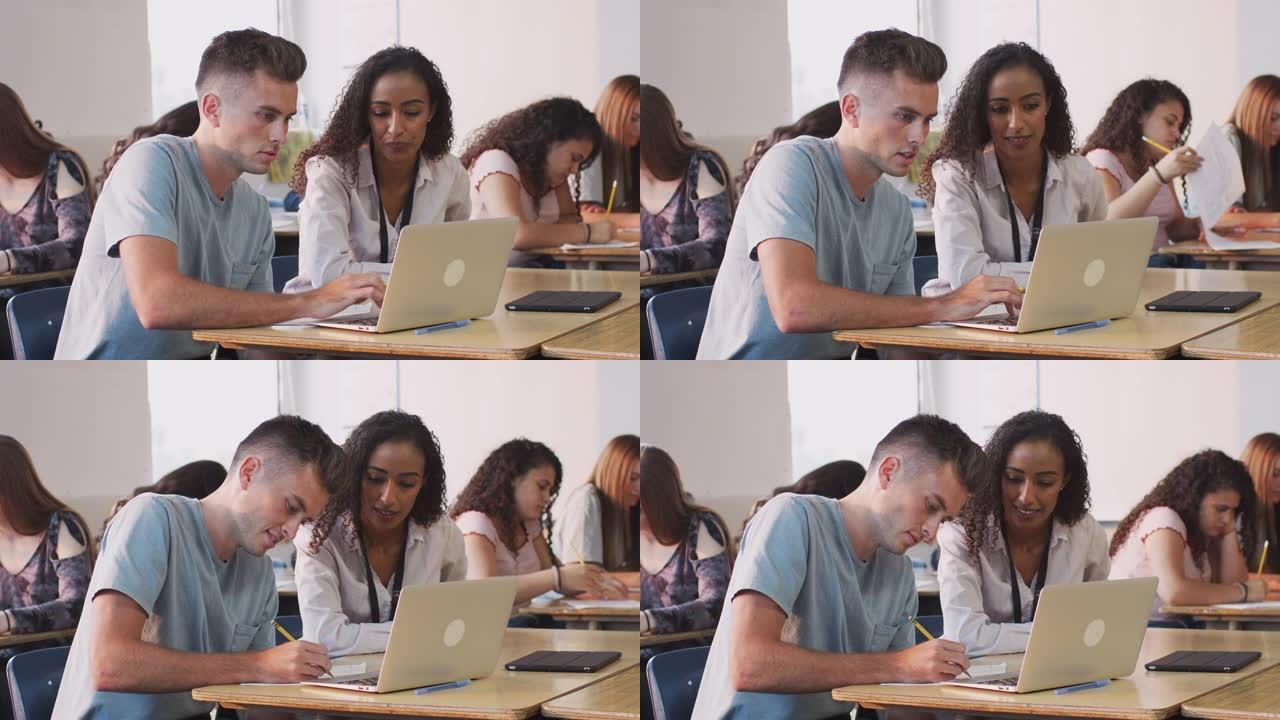 女导师为在笔记本电脑上工作的男生提供一对一的支持