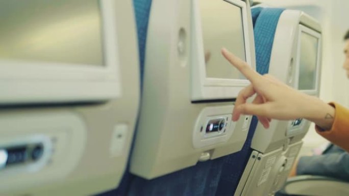乘飞机飞行时戴着耳机的年轻亚洲女性