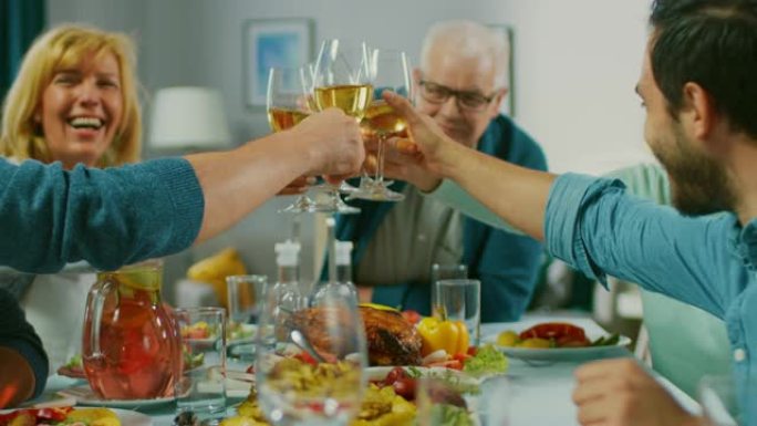 大家庭和朋友在家里庆祝，不同的人群聚集在餐桌旁。吃饭、喝酒、敬酒和娱乐。白天的节日。