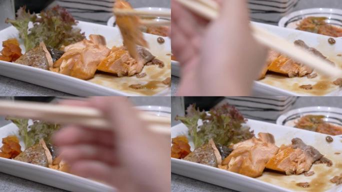 女孩手吃盐鲑鱼烤架。日本料理