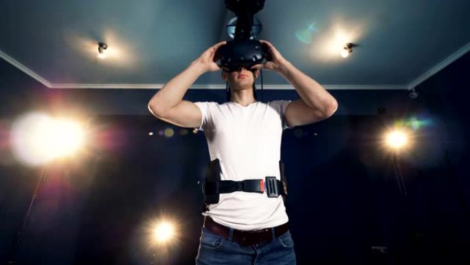 一个人戴上VR护目镜并开始移动他的手。虚拟现实耳机玩游戏360。