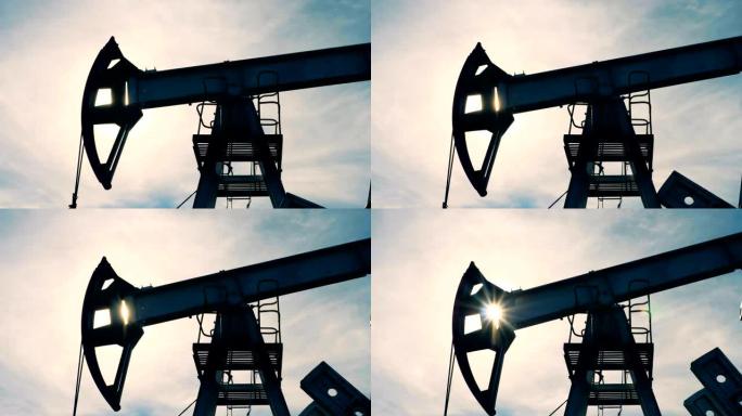 石油井架在太阳背景下工作，特写。金属塔在油田上抽油。