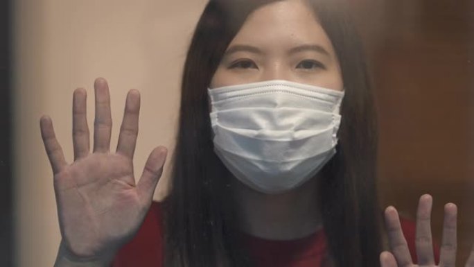 亚洲女性透过窗户自我检疫寻找冠状病毒或新型冠状病毒肺炎