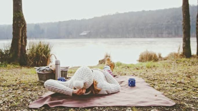 Serene女士女士在斯洛文尼亚Prekmurje的宁静秋天湖畔的毯子上放松