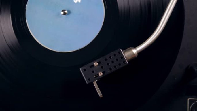 音乐播放器工作时，金属针刮擦黑胶唱片。