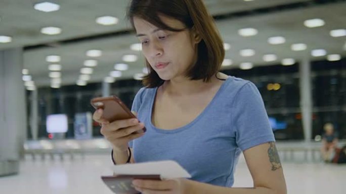 旅游妇女使用电话在机场办理登机手续