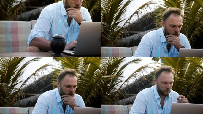 使用笔记本电脑在异国情调的棕榈树下努力度假，特写相机倾斜到专注于快乐的商人身上。