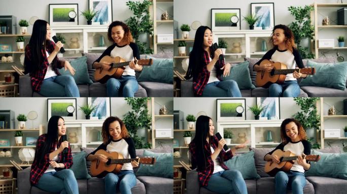 女性朋友在家里玩得开心，在电视遥控器里弹吉他唱歌，一起享受家里的休闲活动。音乐和文化概念。