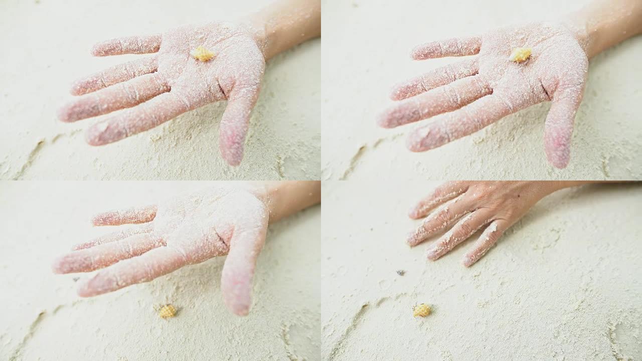 CU女子手握贝壳沙蟹在白色沙滩上