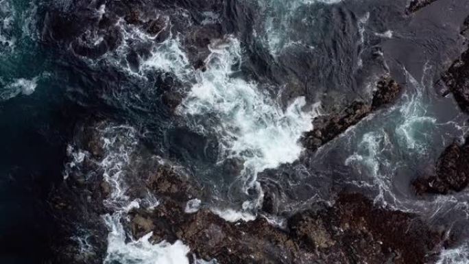 海浪撞击岩石海岸线的抽象鸟瞰图