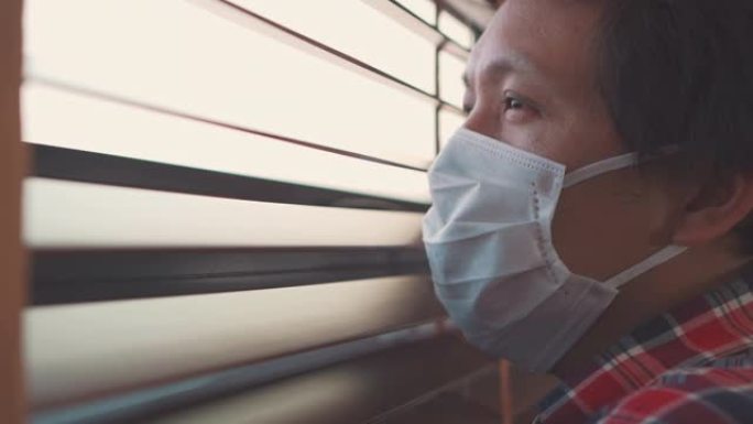 亚洲男子透过窗户自我检疫寻找冠状病毒