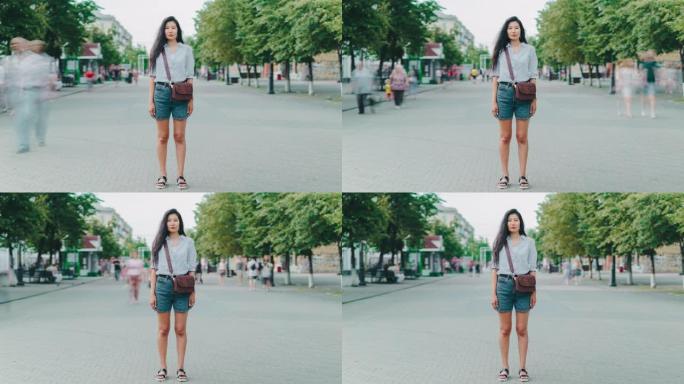 站在城市步行街上看着相机的亚洲女士的延时