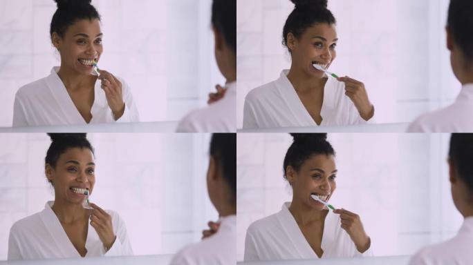快乐健康的年轻非洲妇女刷牙照镜子