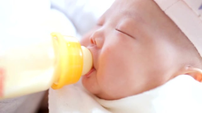 刚出生的婴儿喝奶瓶中的牛奶