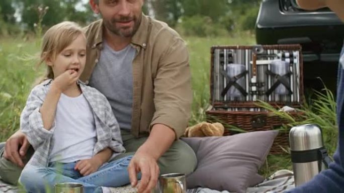 小女孩和父母野餐野餐吃水果