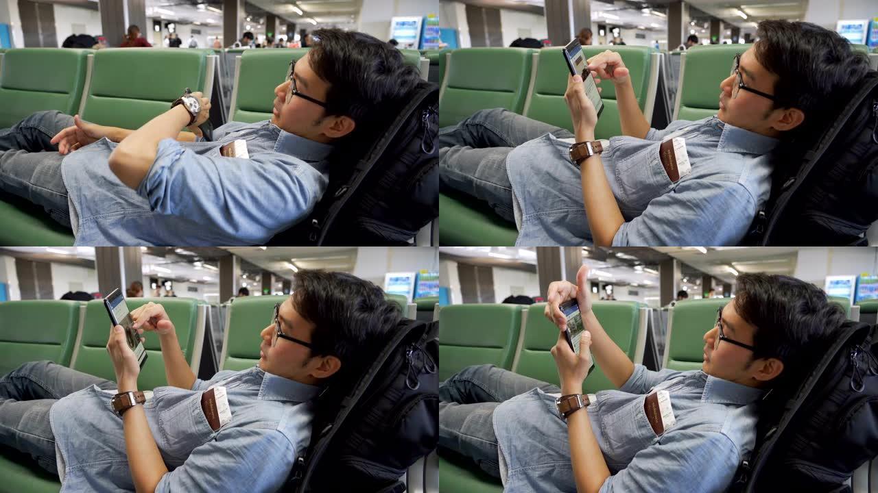 昏昏欲睡的亚洲男子在机场航站楼等待飞机飞行