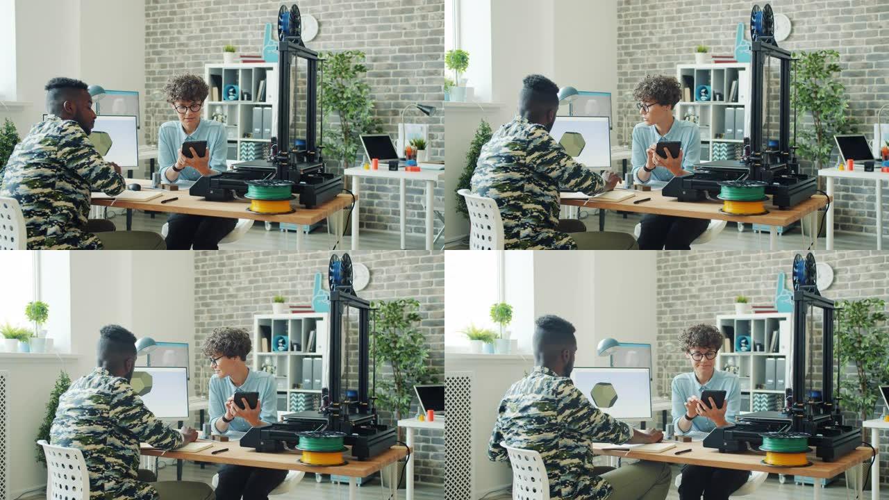 同事在办公室里使用平板电脑、电脑和3d打印机说话工作