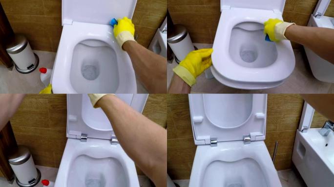戴手套的人的POV润湿海绵和清洁浴室的厕所