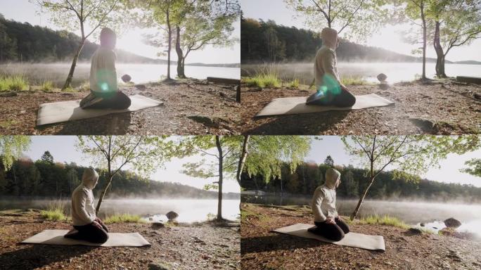 一个早上在湖边做瑜伽的人