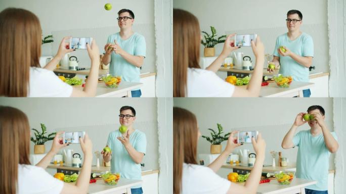 女友用智能手机拍照时，学生在厨房里玩苹果