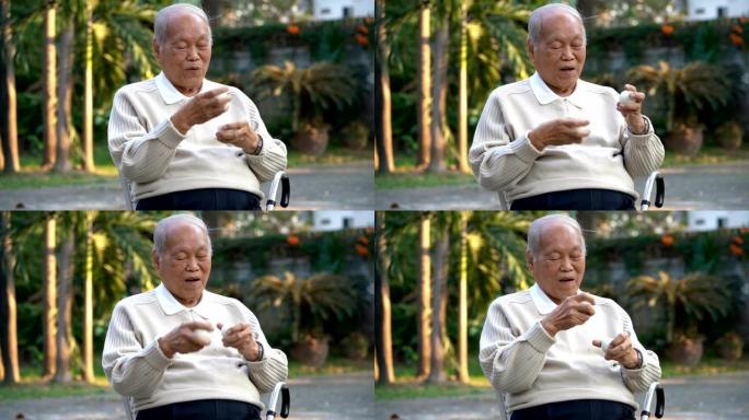 亚洲老人在户外使用白色大理石按摩球锻炼