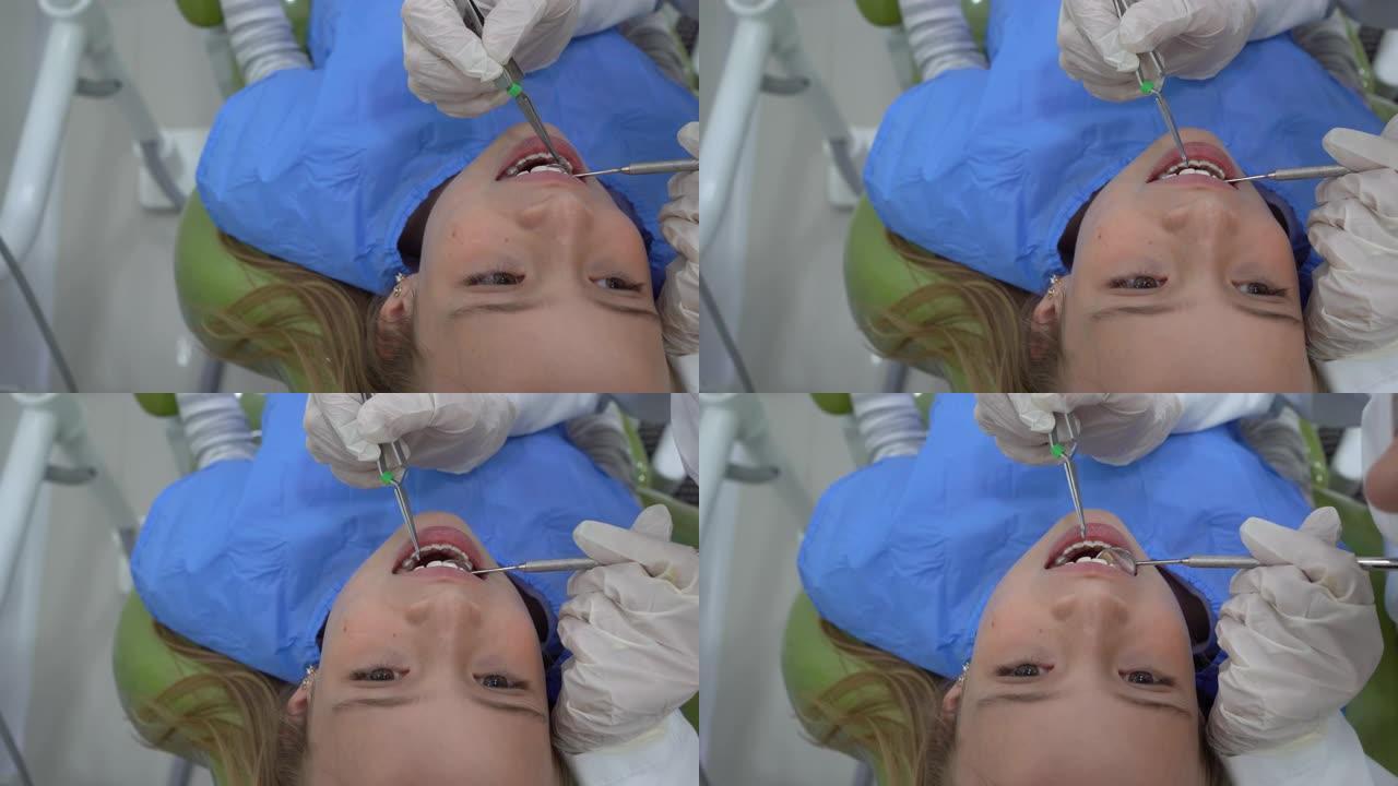 无法识别的牙医在咨询期间检查小女孩的牙齿
