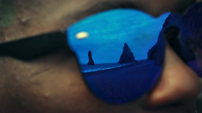 欣赏雷尼斯法拉黑沙滩的人。太阳镜反射。