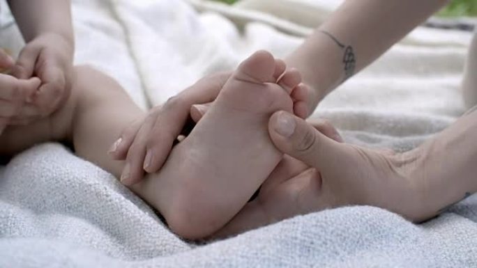 母亲抚摸婴儿的脚按摩小孩子的脚丫子