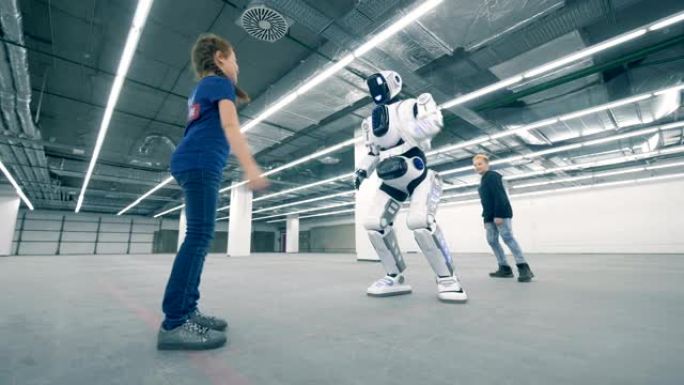 一个男孩和一个女孩在戏弄一个类似人类的机器人