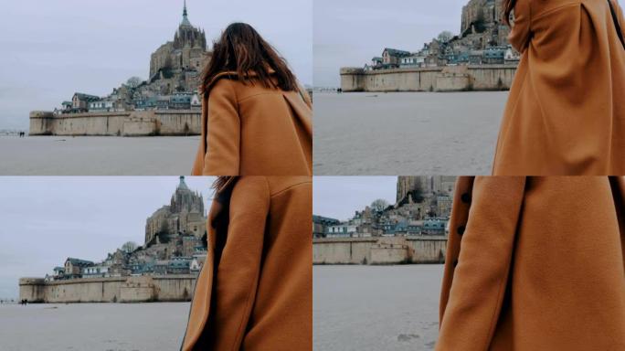 穿着优雅外套的时尚博主女人走向圣米歇尔城堡地标慢动作的后视特写