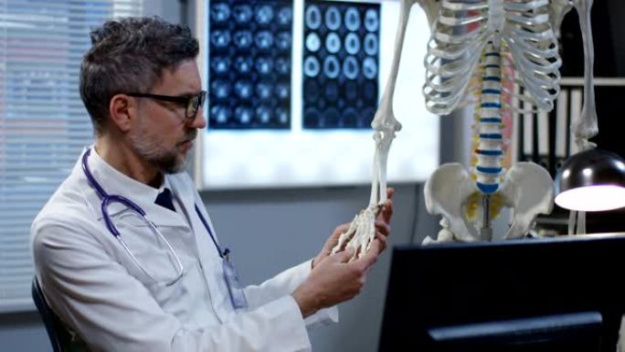 医生使用骨骼模型分析手部解剖结构