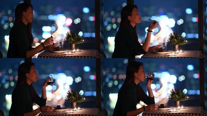 一位亚洲中国美丽的年轻女士在神奇的时刻，黄昏放松和享受的时刻在她的公寓里吃甜点