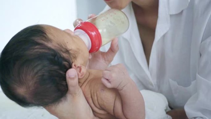 在家中用奶瓶喂养亚洲男婴的特写镜头，慢动作