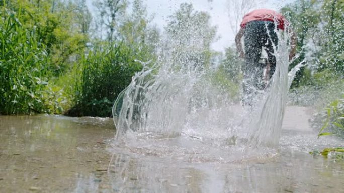 SLO MO (实时慢速) 山地自行车手跳入水坑