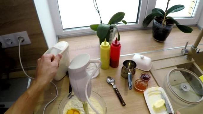 人的POV将鸡蛋添加到玻璃碗中并混合面糊